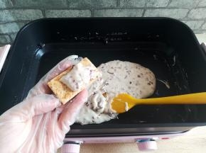 戴一次性手套，捏一小块炒好地牛扎夹心放到一块咸蛋黄方块酥饼干中间