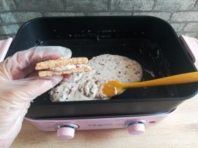 把另一块咸蛋黄方块酥饼干贴到刚才那块饼干上，稍微压一下，不要太用力，别压碎了