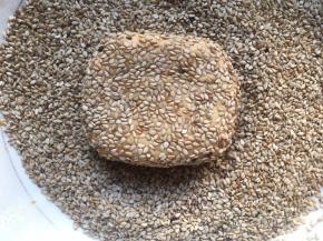 再取适量面团，利用双手掌心稍微揉成球，放入碗中滚一圈，让面团均匀的沾上白芝麻，再用手指轻轻压扁至自己喜欢的形状或者厚度；