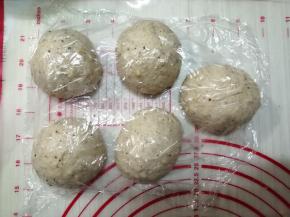 把静置好的面团轻压排气，把小气泡捏破，面团分成5等份并滚圆，盖上保鲜膜，松弛15分钟
