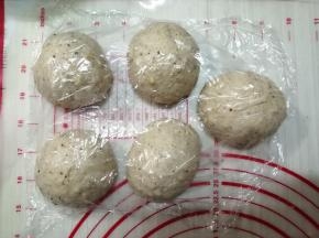 把静置好的面团轻压排气，把小气泡捏破，面团分成5等份并滚圆，盖上保鲜膜，松弛15分钟
