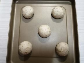 松驰好的面团重新再压扁，滚圆，放在烤盘上