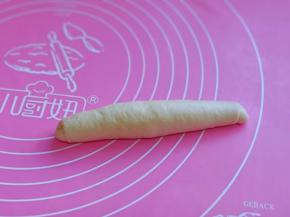 取一块面团，用擀面杖擀长舌状，由上往下卷起，收口捏紧。