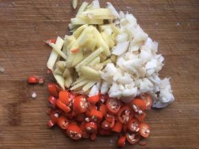 将生姜、大蒜、辣椒都切碎，倒入一个小碗中备用；