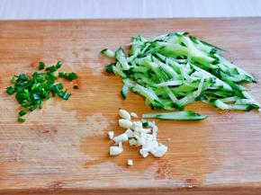 黄瓜洗干净切丝，大蒜去皮切碎，小葱去皮切葱花。