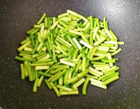 锅底留余油，下入蒜苔翻炒至变色。