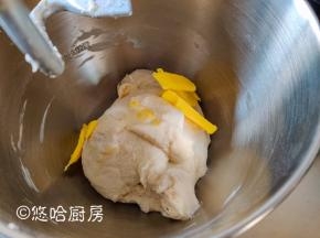 用厨师机搅拌面团至光滑时，放入室温下软化的黄油继续搅拌。