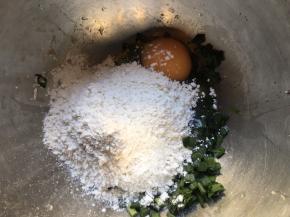 将切好的韭菜末倒入盆中 ，加一勺盐搅拌均匀后静置杀出水份，再磕入鸡蛋，多次少量倒入面粉；