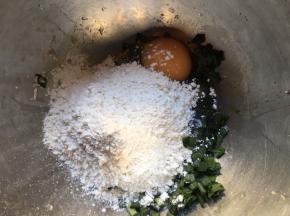 将切好的韭菜末倒入盆中 ，加一勺盐搅拌均匀后静置杀出水份，再磕入鸡蛋，多次少量倒入面粉；