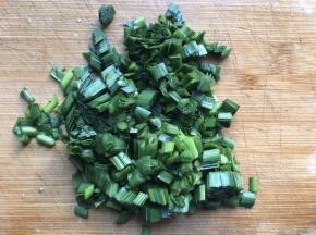 将准备好的韭菜择掉尾部黄叶，清洗干净，然后切掉根部，然后切碎；