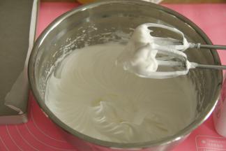 转中速打到细密小泡，加入1/3细砂糖；继续中速打到蛋白细腻光滑，出现纹路，加入最后的细砂糖。中高速，打到湿性发泡，最后转低速整理大气泡。最后的状态，如图，提起打蛋头，大弯钩状态，蛋白霜细腻有光泽。