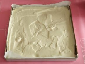 将拌匀的面糊，从30厘米处倒入垫好油纸的金盘中，用刮板刮平，我没有刮很平，因为今天用到的是毛巾面。