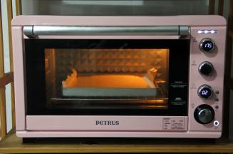 提起金盘，轻震两下，震出大气泡，送入预热好的烤箱中下层，转上下175度，烤20分钟。烤蛋糕期间，发挥你的想象力，给便当盒子画个图，变个造型。