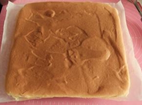 烤完，取出从高处震下烤盘，震出热气。再拎起油纸转移到凉网上。等2分钟，再撕开周围的油纸散热，同时顶部要加盖油纸，防止表面变干。