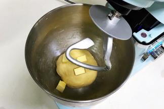 揉至成团，可以拉出粗膜，往搅拌桶内加入黄油。