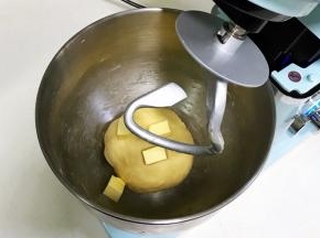 揉至成团，可以拉出粗膜，往搅拌桶内加入黄油。