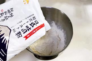 搅拌桶内加入清水、鸡蛋液、糖、盐、金山日式吐司粉、奶粉和酵母粉。