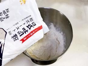 搅拌桶内加入清水、鸡蛋液、糖、盐、金山日式吐司粉、奶粉和酵母粉。