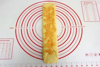 继续往两个方向擀长，放入肉松，稍稍压一下。