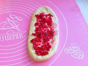 醒好的卷用擀面杖再次擀长舌状，涂上蔓越莓果酱，两边对折，再卷起来，收口朝下，依次做完。