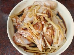 鸡翅洗净后斩块，然后加入料酒、盐、鸡精、生抽、老抽、白砂糖、姜丝和金龙鱼芝麻香油，抓拌均匀后腌制半小时以上