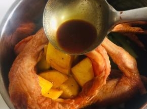 把拌匀的土豆塞到鸡肚子里，料汁儿也倒进去！