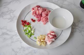 将猪肉肥肉分开，肥猪肉切成小条，瘦肉切成小块，葱蒜辣椒也准备好，水淀粉也调好备用。
