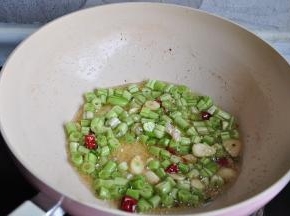 先放入豆角大火炒。豆角比其它菜要费火，我们一定要提前炒它，这样才能与茄子的口感同步。不要一味的追求豆角的菜色和脆感或者是图省事省略这一步，不熟的豆角吃后也容易引起胃肠不适，这一点一定要记住。