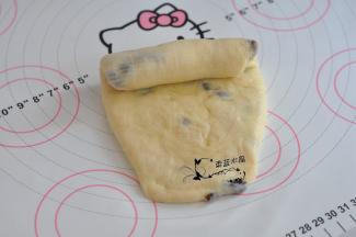 将面团擀成牛舌状，翻面后，由上至下卷起，松弛15分钟。
