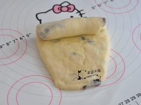将面团擀成牛舌状，翻面后，由上至下卷起，松弛15分钟。