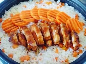 13 等米饭已经熟了，打开把胡萝卜片和鸡肉码在米饭上，淋上一半的料汁在焖2分钟左右。