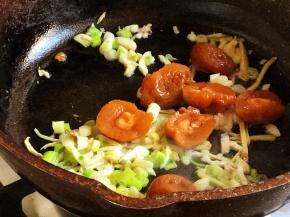 下入葱、蒜、梅子翻炒出香味。