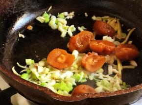 下入葱、蒜、梅子翻炒出香味。