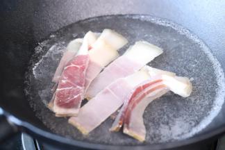 火腿肉切薄片，炒锅内倒入适量的水，煮开，放入火腿肉汆一下，沥干水分备用。
