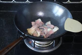 炒锅内放入少量的油，放入火腿肉爆炒至变为深红色。
