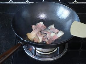 炒锅内放入少量的油，放入火腿肉爆炒至变为深红色。