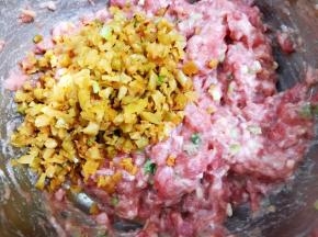 肉馅搅打上劲后加入榨菜末拌匀