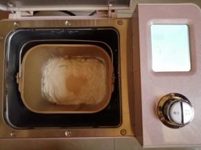 往面包桶倒入水、蛋液、糖、盐、奶粉和面粉，在面粉顶端倒入酵母，把面包桶放入到东菱JD08面包机里，选择和面程序10分钟。在面包机和面的时候，把做馅料的3种食材拌在一起，分成8份，搓圆备用