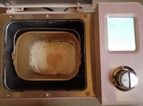 往面包桶倒入水、蛋液、糖、盐、奶粉和面粉，在面粉顶端倒入酵母，把面包桶放入到东菱JD08面包机里，选择和面程序10分钟。在面包机和面的时候，把做馅料的3种食材拌在一起，分成8份，搓圆备用