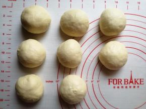 和好的面团取出，分割成8份小面团，大概是60克一个，滚圆，盖上保鲜膜，松弛15分钟