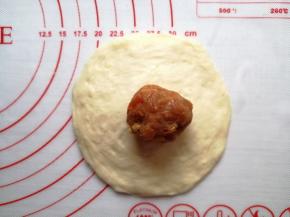 用擀面棍把小面团擀成中间厚，四周薄的圆形，馅料放在中间