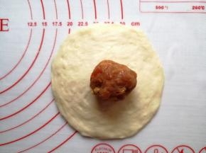 用擀面棍把小面团擀成中间厚，四周薄的圆形，馅料放在中间