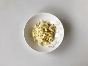 把大蒜拍扁，切成蒜末。