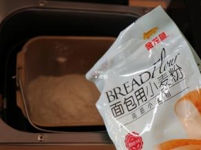 将面团材料中的纯牛奶和鸡蛋液倒入面包机的面包桶中，盐、白砂糖对角放，倒入金龙鱼面包用小麦粉，这个粉采用100%进口小麦为原料，麦香浓郁，制作过程中易膨胀易拉丝，吸水性也好，面粉质量稳定性较好，成品香软可口；