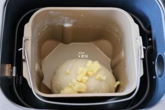 揉面程序结束后倒入黄油，继续选择和面程序揉面，揉面程序结束后选择发酵程序开始发酵；