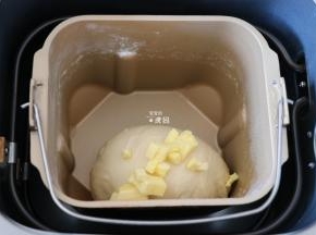 揉面程序结束后倒入黄油，继续选择和面程序揉面，揉面程序结束后选择发酵程序开始发酵；