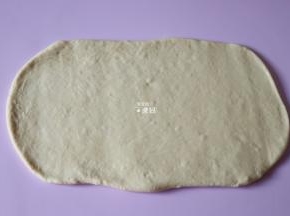 将发酵好排好气的面团用擀面杖擀成一个长方形；