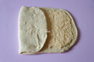 将剩下的没有椰蓉馅的三分之一面皮向中间折过来，如图；