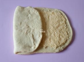 将剩下的没有椰蓉馅的三分之一面皮向中间折过来，如图；