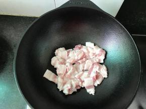 铁铸锅倒入一点肉，放入五花肉煸炒稍微变色